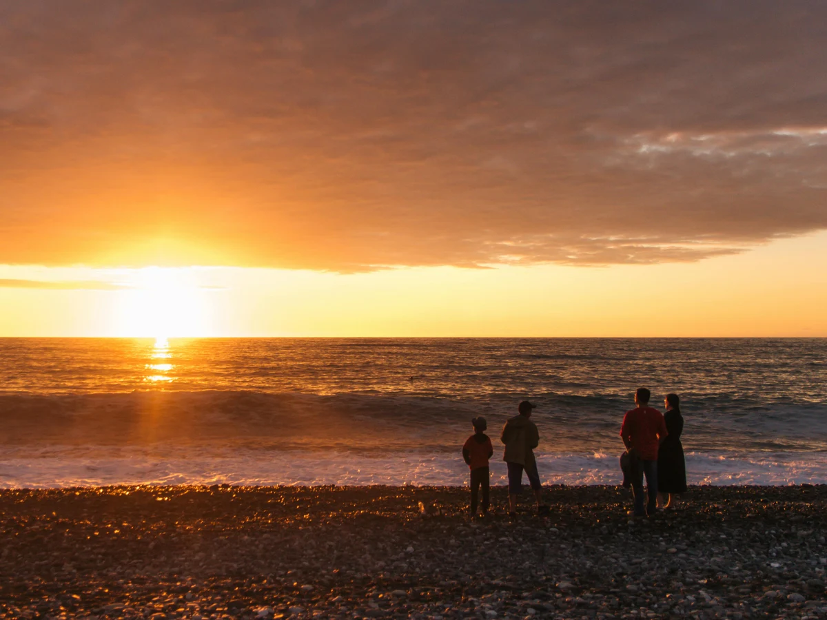 Photo of a Family on a Beach During Sunset
