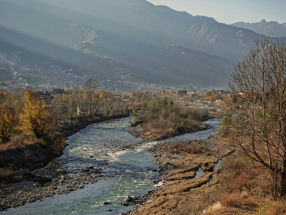 a river running through a lush green hillside