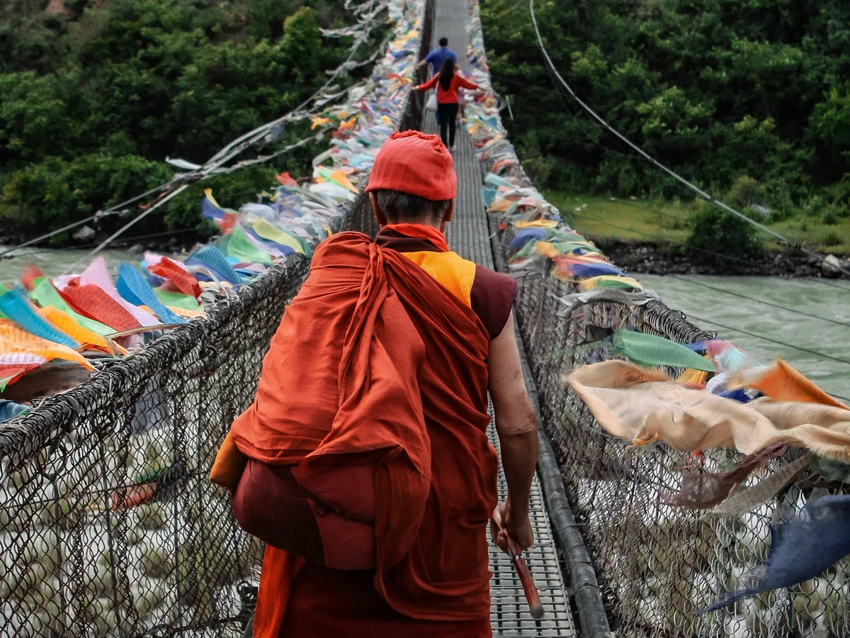 Monk crossing bridge in Bhutan