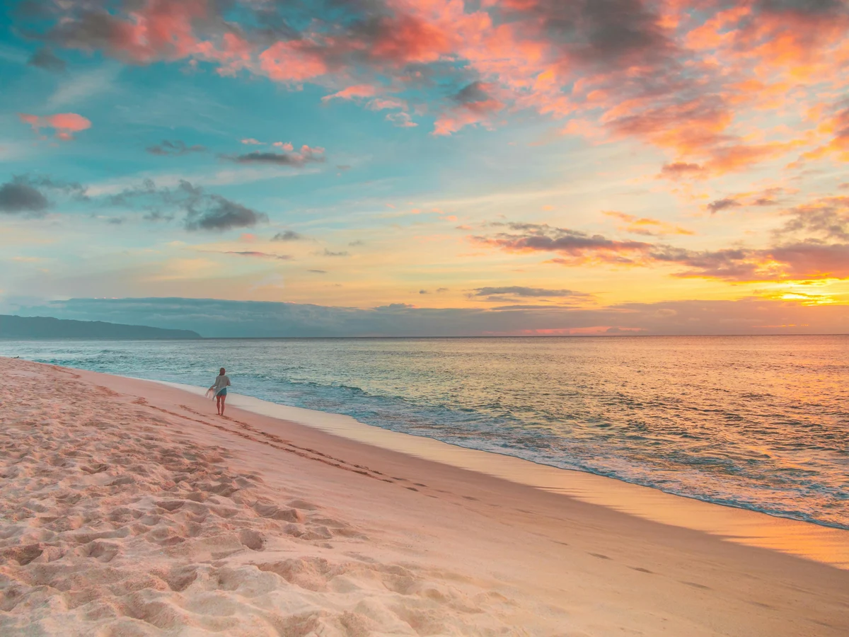 Person Walking on Beach during Sunset