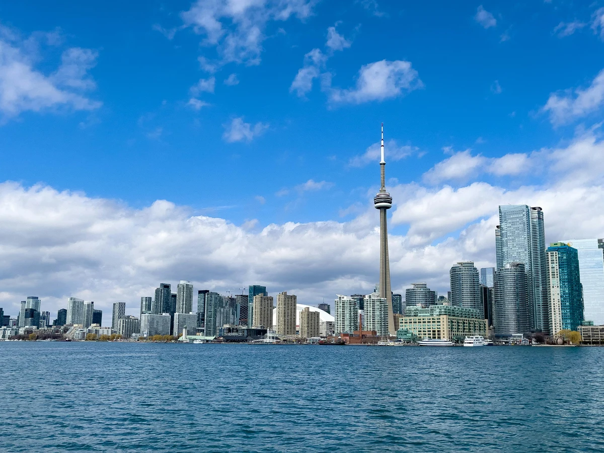 Vibrant Toronto cityscape featuring CN Tower and skyscrapers under a clear blue sky.