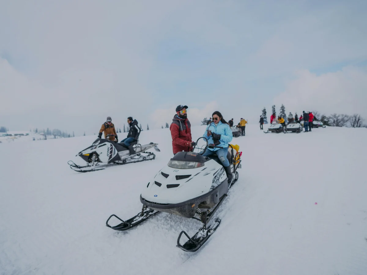 People Riding Snowmobiles