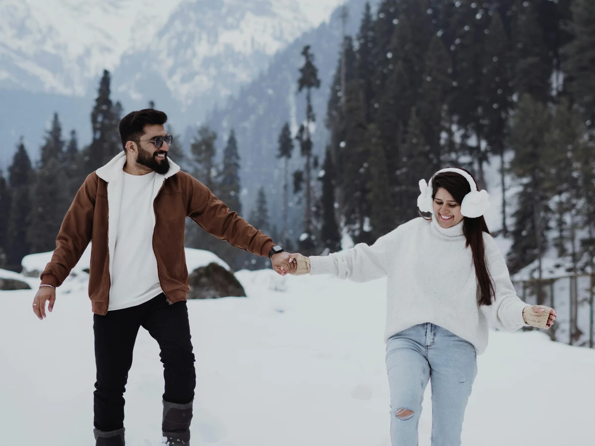 Couple Enjoying Winter Walk in Snowy Mountains