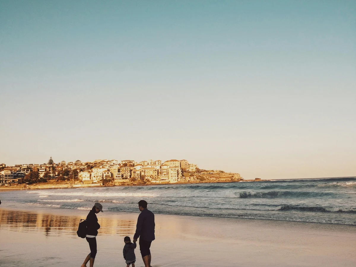 Man and Woman Walking With Boy in Seashore